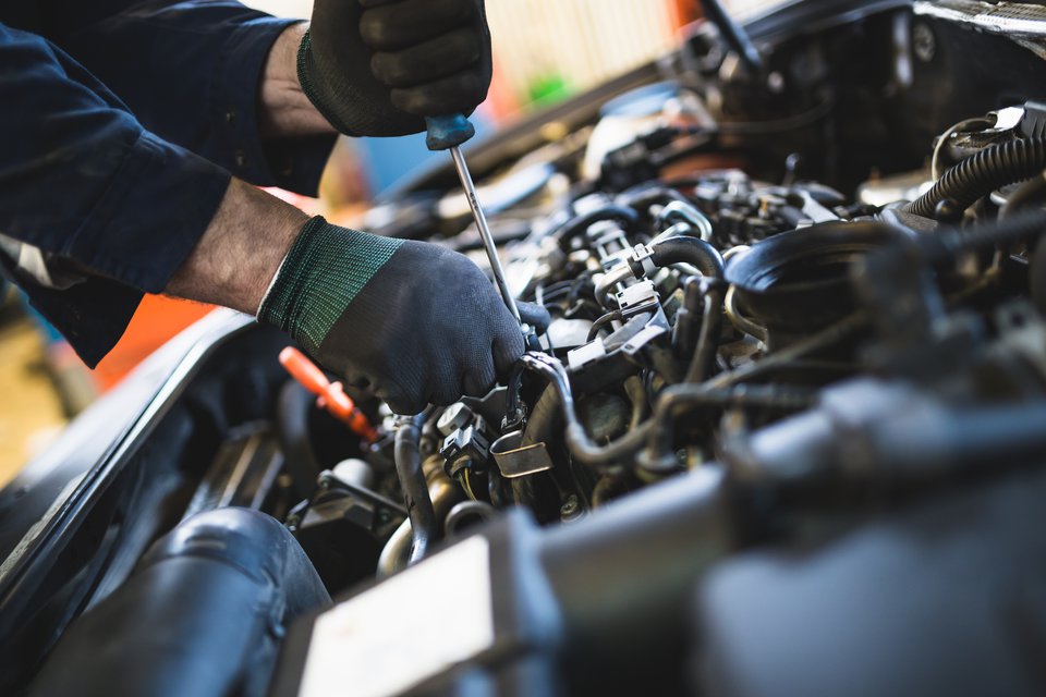Práce na motoru vozu v dílně autoservisu